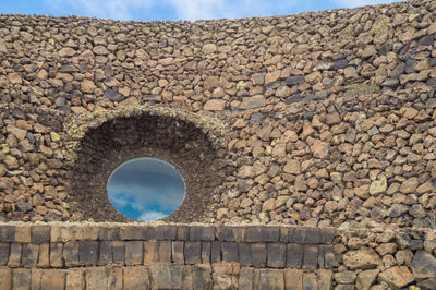 Low angle view of stone wall against sky