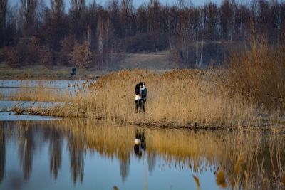Man standing by lake in forest