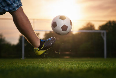 Low section of person playing soccer ball