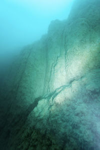 Low angle view of rock formation in sea against sky