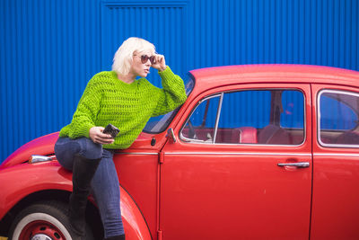 Full length of woman standing by car