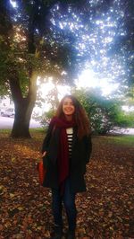 Portrait of young woman standing in park during autumn