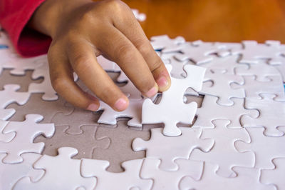 Cropped hand of child playing puzzle