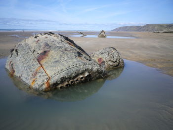 Close-up of rocks on beach against sky