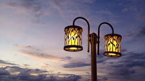 Low angle view of illuminated street light against sky at sunset