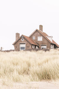 House on field against clear sky