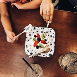 Midsection of woman holding ice cream on table