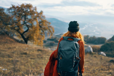 Rear view of woman standing against trees