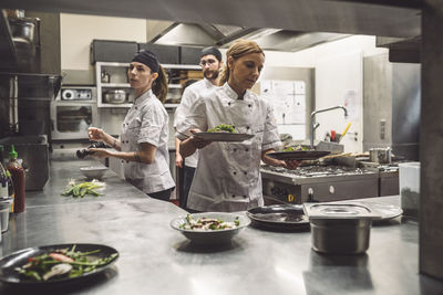 Female and male chefs working in commercial kitchen
