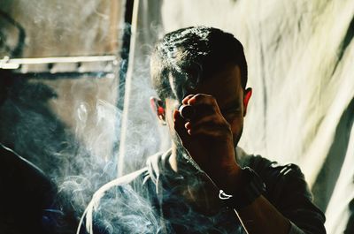 Portrait of man standing amidst smoke