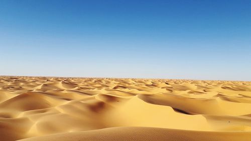 Scenic view of desert against clear blue sky