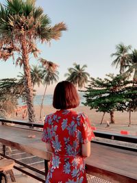 Rear view of woman looking at swimming pool against sky