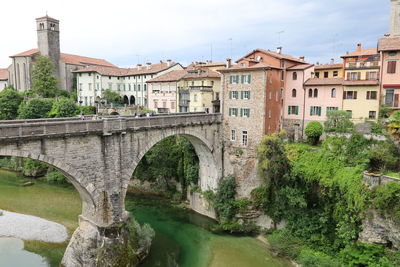 Arch bridge over river against sky