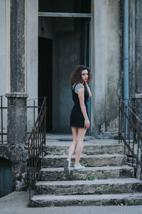 Full length of woman standing on staircase against building