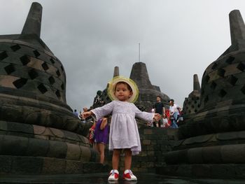 Portrait of happy girl standing against sky