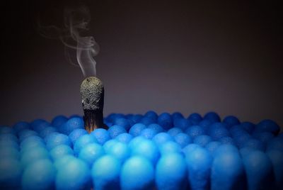 Close-up of matchsticks and smoke against gray background