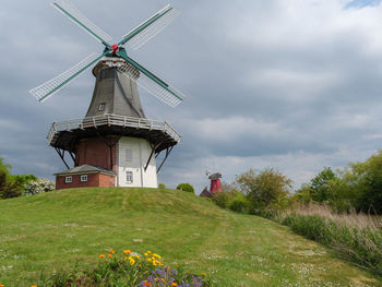 Traditional windmill on field against sky