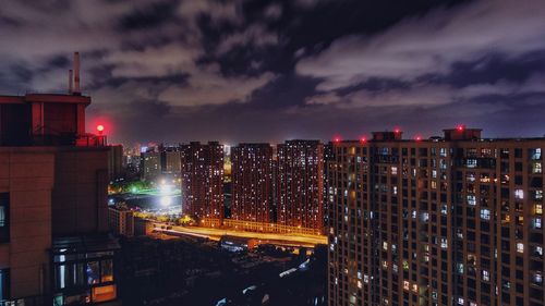 High angle view of illuminated buildings against sky at night