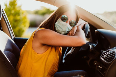 Midsection of woman sitting in car