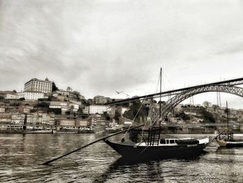 Bridge over river in city against sky