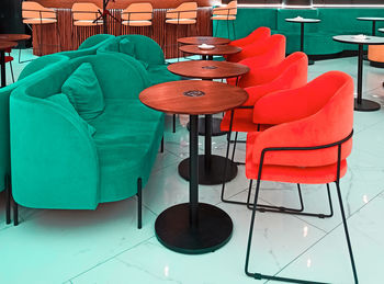 Empty chairs and tables at sidewalk cafe