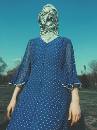 Midsection of woman standing against clear blue sky