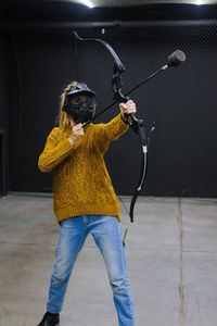 Rear view of woman photographing with umbrella