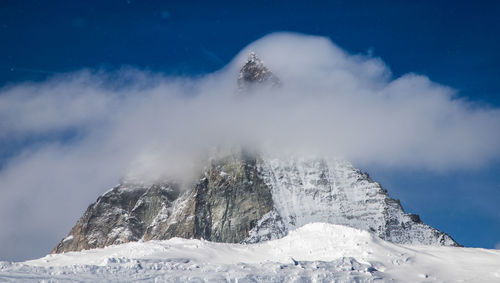 Low angle view of snowcapped mountains against sky