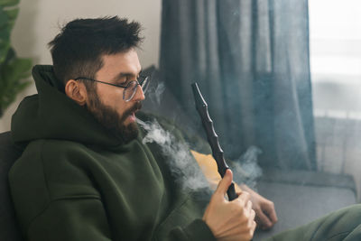 Side view of man smoking cigarette