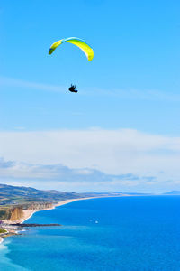 People paragliding over sea against sky