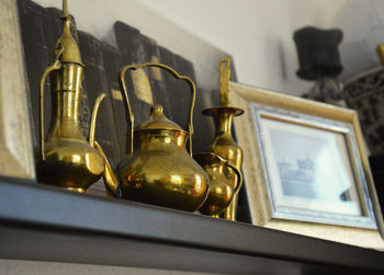 Low angle view of antique bronze utensils on shelf