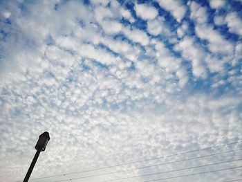 Low angle view of street light against cloudy sky