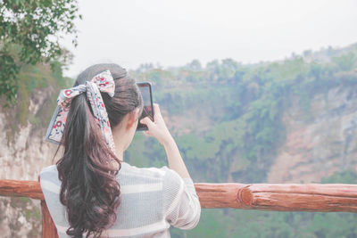 Side view of woman looking away against mountain