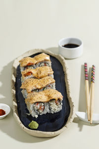 Japanese sushi rice roll with spicy mentai sauce topping on blue plate