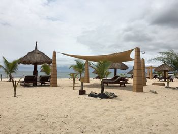 Lounge chairs below sunshade at sandy beach