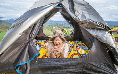 Rear view of man sitting in tent