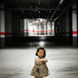 Portrait of cute girl standing in corridor