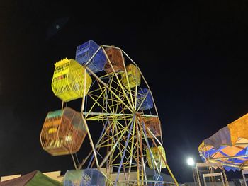 Low angle view of illuminated ferris wheel against sky at night