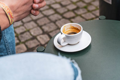 Midsection of coffee cup on table at cafe