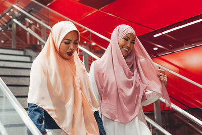Smiling women moving down on staircase