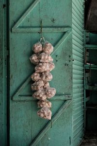 Close-up of garlic hanging on wooden door