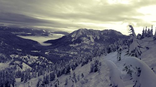 Snow covered mountain against cloudy sky