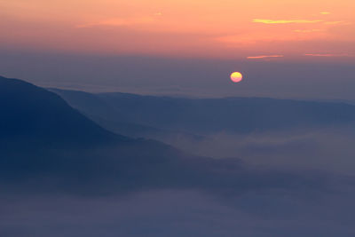 Scenic view of silhouette mountains against romantic sky at sunset