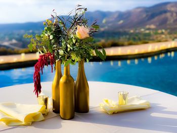 Close-up of yellow flower on table by swimming pool