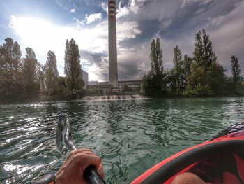 Person by lake against sky