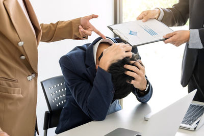 Midsection of business people having argument in office