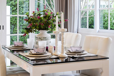 Potted plant on table by window at home