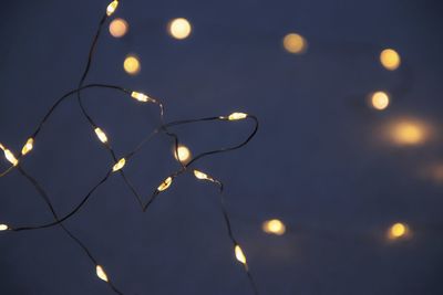 Low angle view of illuminated lights against sky at night