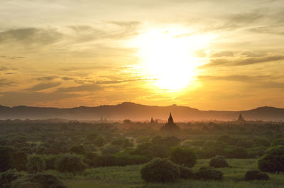 Scenic view of landscape against cloudy sky during sunset, temples 