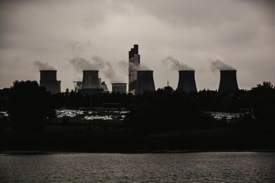 Buildings by sea against sky